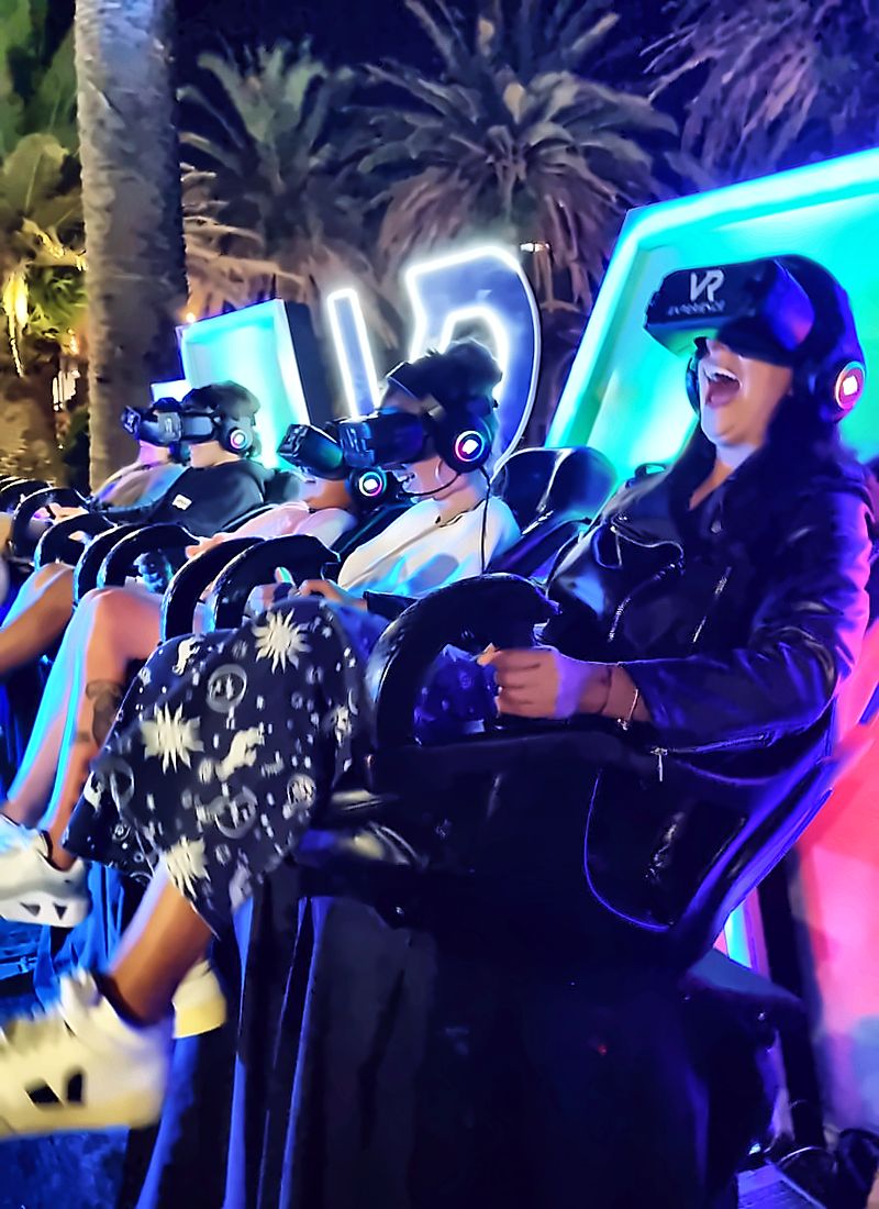 Mujer gritando de emoción con el visor puesto, frente a las flechas de neón azul